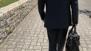 介護脱毛について考えながら歩く男性